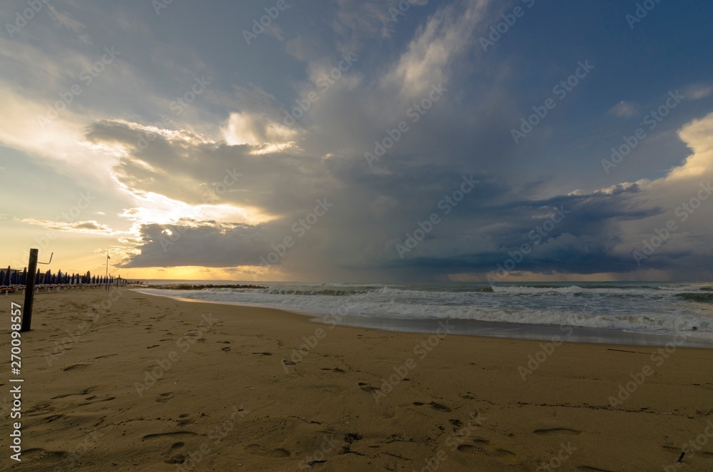 Seascape with beach, rocks and cloudy sky