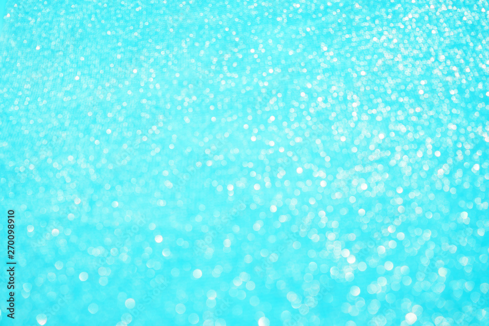 Fototapeta premium Blurred bokeh light blue background, Christmas and New Year holidays background. Party concept. Festive holiday card bright backdrop. Defocused. Flat lay, top view, copy space.