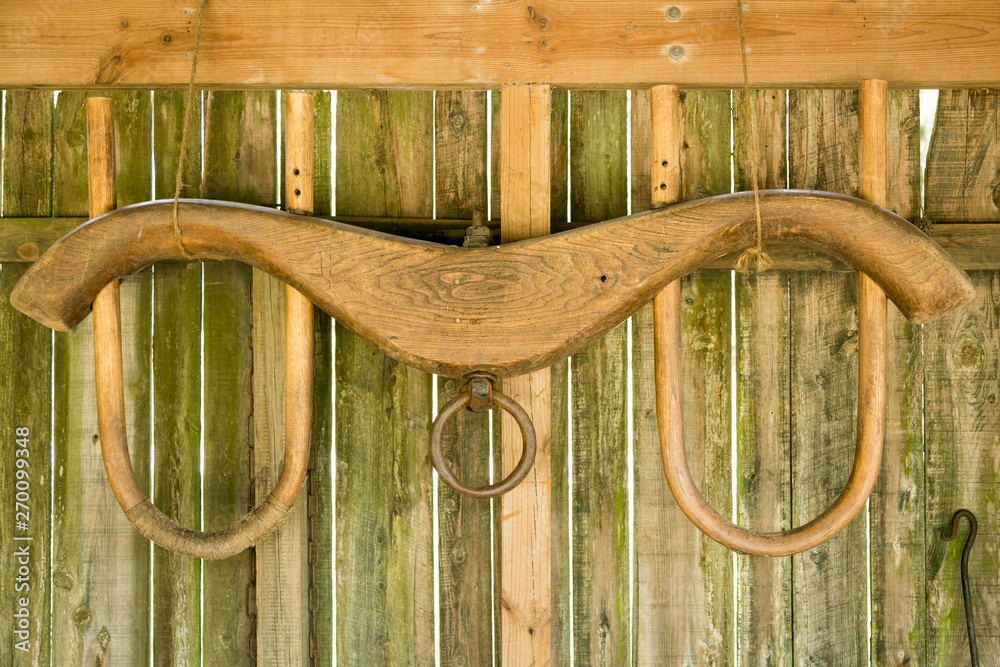 Antique wooden yoke for animals to wear when pulling a plow. Stock Photo Adobe Stock