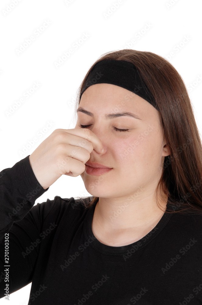 Teen girl standing with eyes and nose closed for stink Teen girl standing with eyes and nose closed for stink