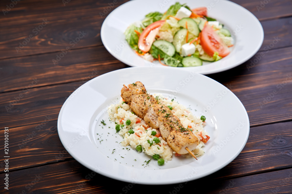 chicken kebab with rice and vegetables on the wooden background chicken kebab with rice and vegetables on the wooden background