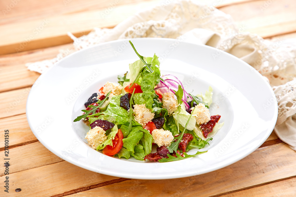 vegetarian salad with dried tomatoes and croutons on the wooden background vegetarian salad with dried tomatoes and croutons on the wooden background