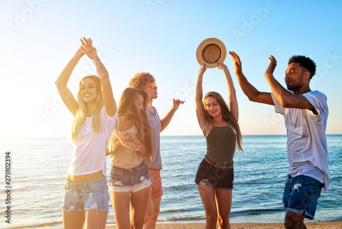 Group of friends dancing on the beach