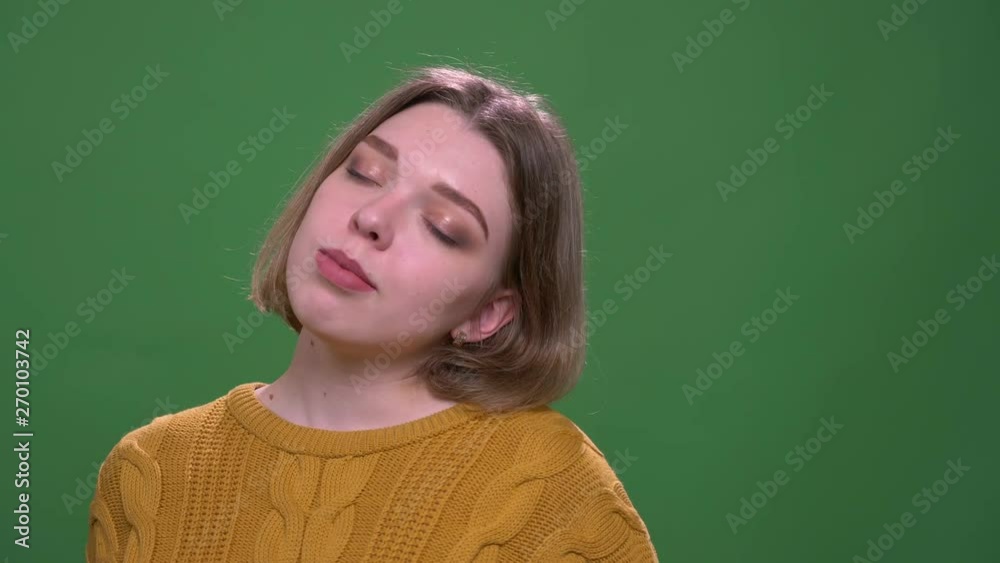 Closeup shoot of young attractive short haired female dancing with joy looking at camera with background isolated on green Closeup shoot of young attractive short haired female dancing with joy looking at camera with background isolated on green