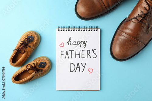 Brown leather shoes, children's shoes and notebook with inscription happy fathers day on color background, space for text and top view