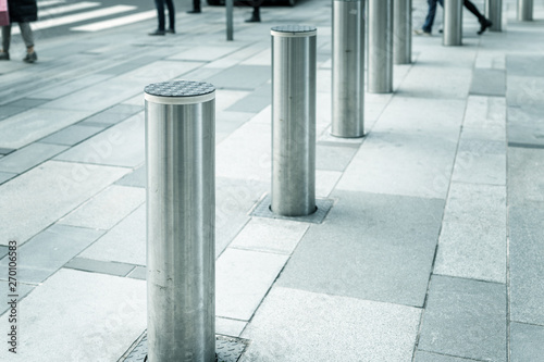 Stainless steel bollard entering pedestrian area on Vienna city street. Car and vehicle traffic access control photo