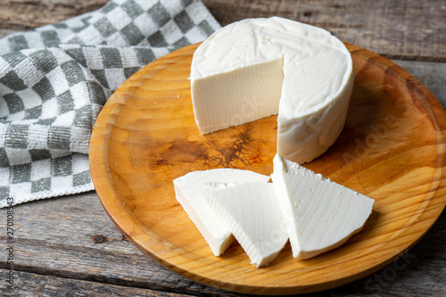 Fresh and tasty mexican panela cheese on wood background photo