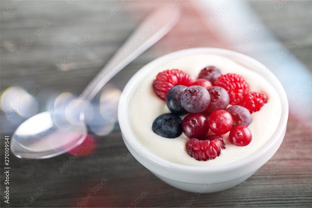 Yogurt with forest berries on wooden table Yogurt with forest berries on wooden table