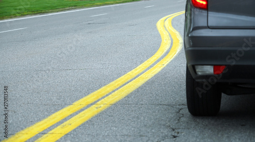 close up on car on the street with curved double yellow line