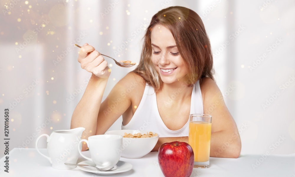 Attracive young woman enjoying tea and fruits on breakfast Attracive young woman enjoying tea and fruits on breakfast