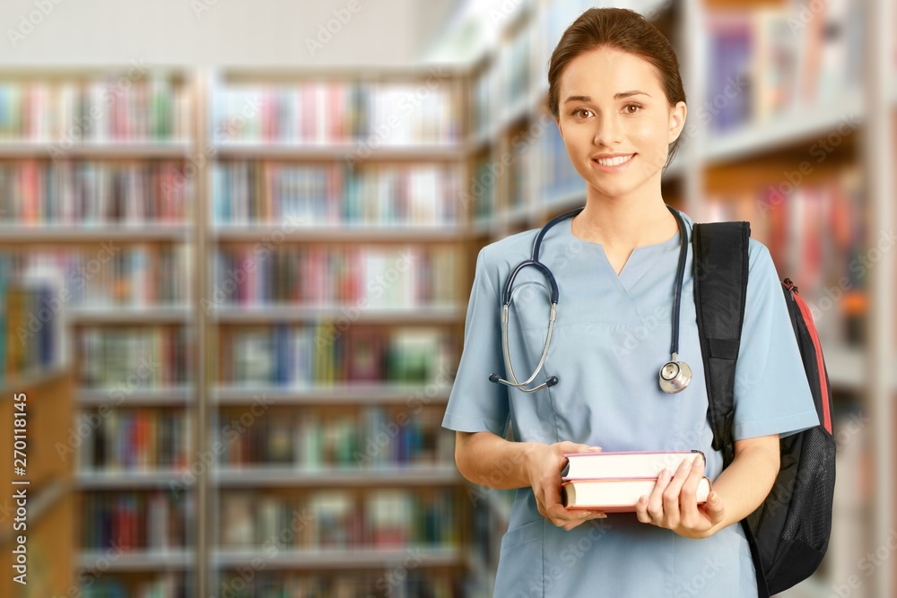 Nurse student with books and stethoscope in library Nurse student with books and stethoscope in library