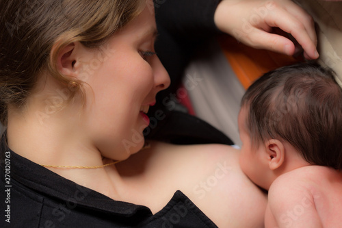 young woman breastfeeding her newborn baby photo