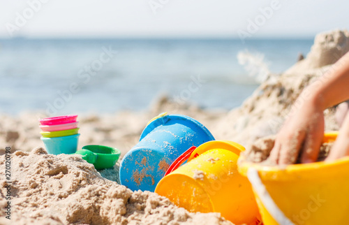 Kind spielt mit Eimer im Sand am Strand