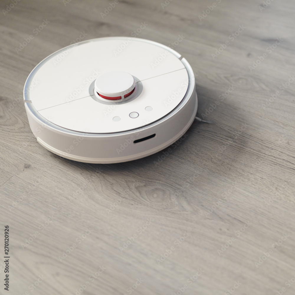 robotic vacuum cleaner on laminate floor in action robotic vacuum cleaner on laminate floor in action