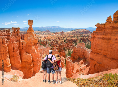 Fotografia Family standing next to Thor's Hammer hoodoo on top of  mountain looking at beautiful view