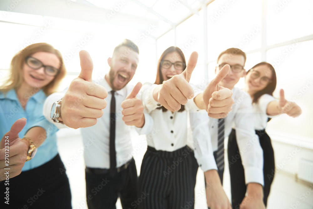 Obraz premium close up. happy business team showing thumbs up.