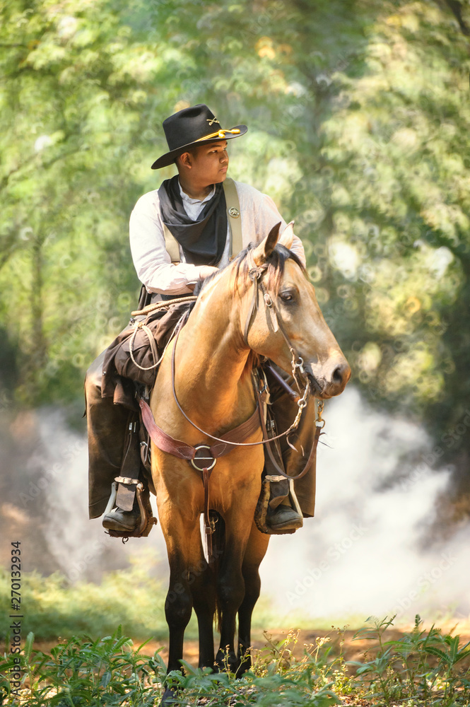 Obraz premium cowboy with his purebred horse standing in the forest