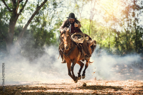 Cowboy riding a horse carry...