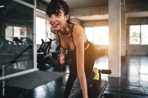 young fitness woman execute exercise with exercise-machine in gym.