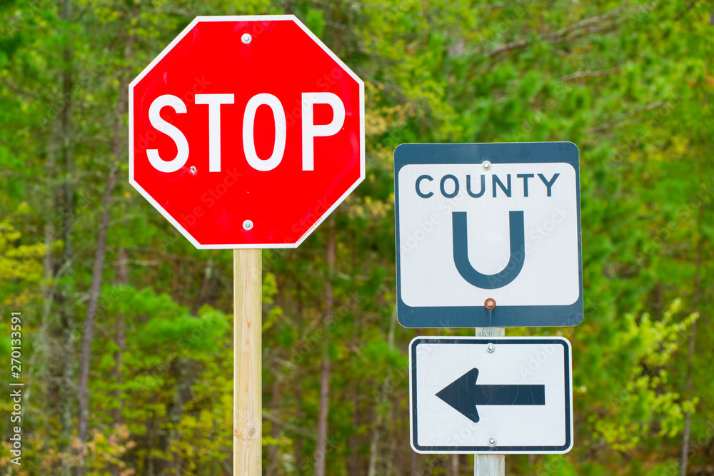 County road sign 'U' and stop sign with Spring trees in background - taken rural Wisconsin