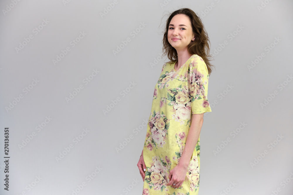 Life is a success. I am pleased with myself. Concept photo of a happy smiling woman satisfied life contented brunette girl in a yellow dress on a gray background with flowing hair. Life is a success. I am pleased with myself. Concept photo of a happy smiling woman satisfied life contented brunette girl in a yellow dress on a gray background with flowing hair.