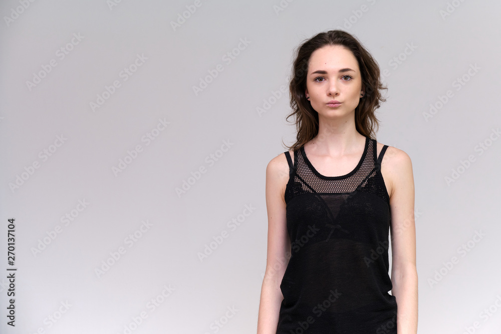 Life is a success. I am pleased with myself. Concept photo of a happy smiling woman satisfied life contented brunette girl in a black T-shirt and jeans on a gray background with flowing hair. Life is a success. I am pleased with myself. Concept photo of a happy smiling woman satisfied life contented brunette girl in a black T-shirt and jeans on a gray background with flowing hair.