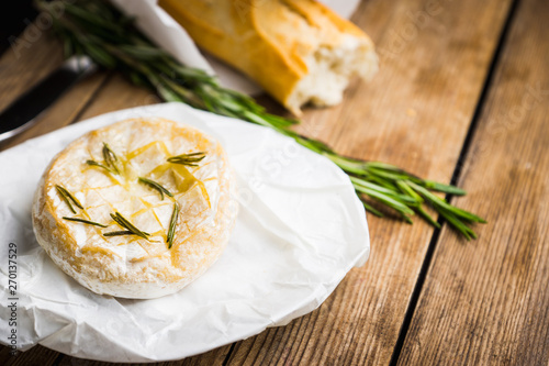 Baked camembert cheese with toasts and rosemary herbs on the rustc background. Selective focus. Shallow depth of field. photo