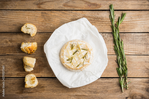 Baked camembert cheese with toasts and rosemary herbs on the rustc background. Selective focus. Shallow depth of field. photo