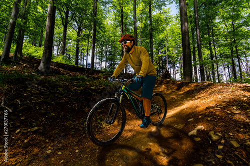 Cycling man riding on bike in mountains forest landscape. Cycling MTB enduro flow trail track. Outdoor sport activity.