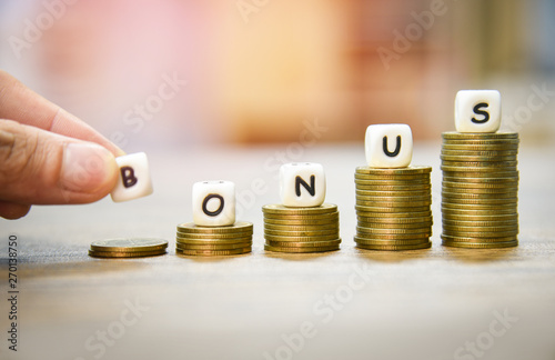 Yearly Bonus concept / hand holding words of bonus on stack coins staircase photo