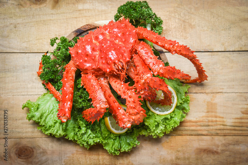 Alaskan King Crab Cooked steam or Boiled seafood and lettuce salad vegetable with wooden background - red crab hokkaido