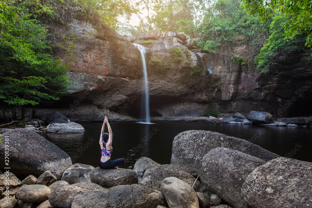 Young girl asian women is playing yoga in front of the waterfall. Young girl asian women is playing yoga in front of the waterfall.