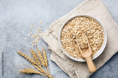 Oat flakes, oats or rolled oats in bowl. Table top view photo