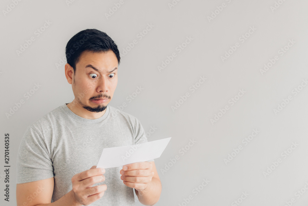 Man is shocked and surprised with the white mail message or the bill. Man is shocked and surprised with the white mail message or the bill.