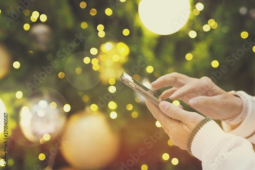 People using technology smartphone closeup Christmas tree blur background DIGITAL CAMERA