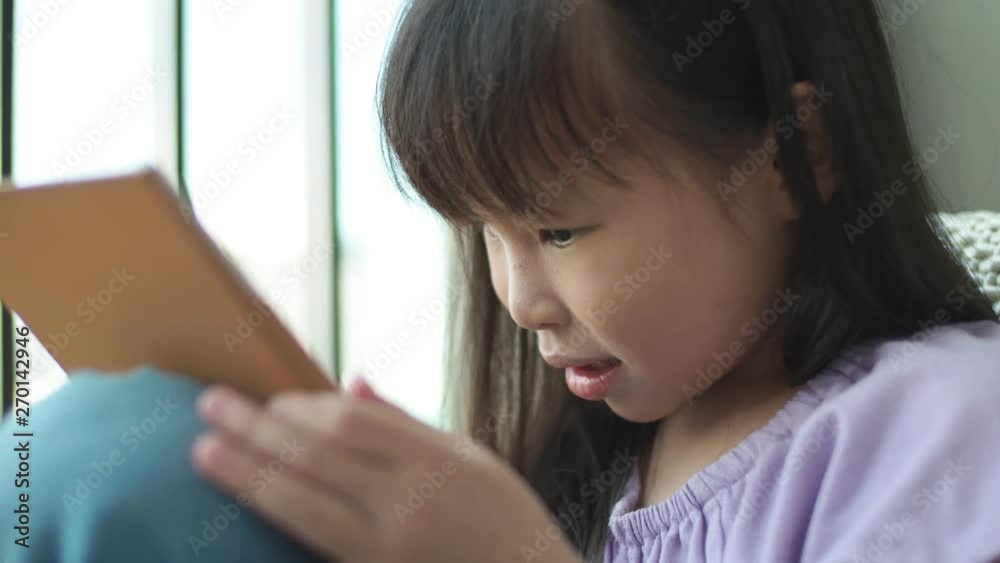 Little asian girl playing games on tablet computer Little asian girl playing games on tablet computer