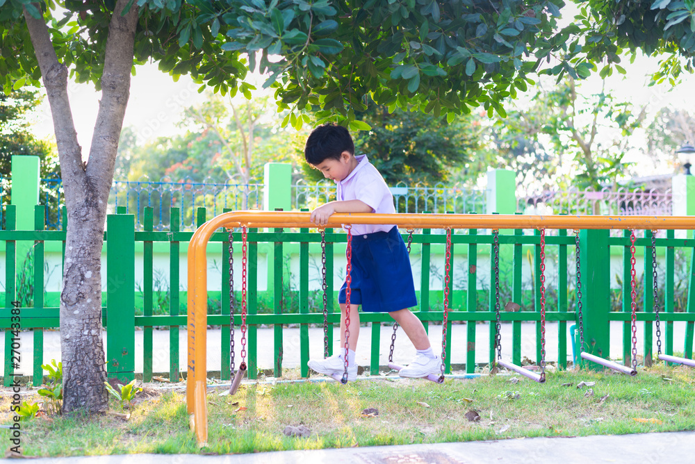 Asian boy hang the monkey bar or balance bar for balance at outdoor playground. Asian boy hang the monkey bar or balance bar for balance at outdoor playground.