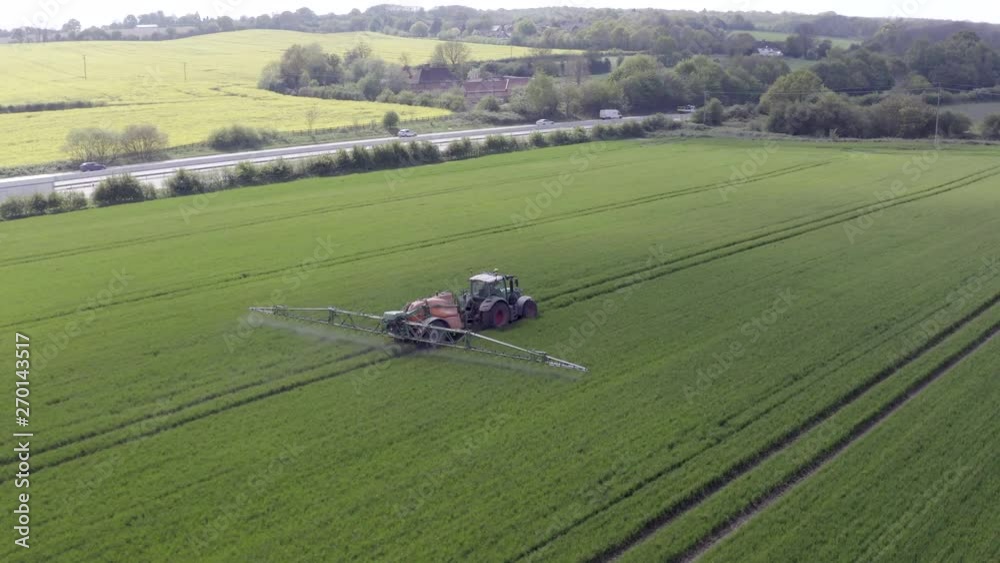 Tractor Spraying Fields on an Arable Farm with Glyphosate Herbicide Tractor Spraying Fields on an Arable Farm with Glyphosate Herbicide