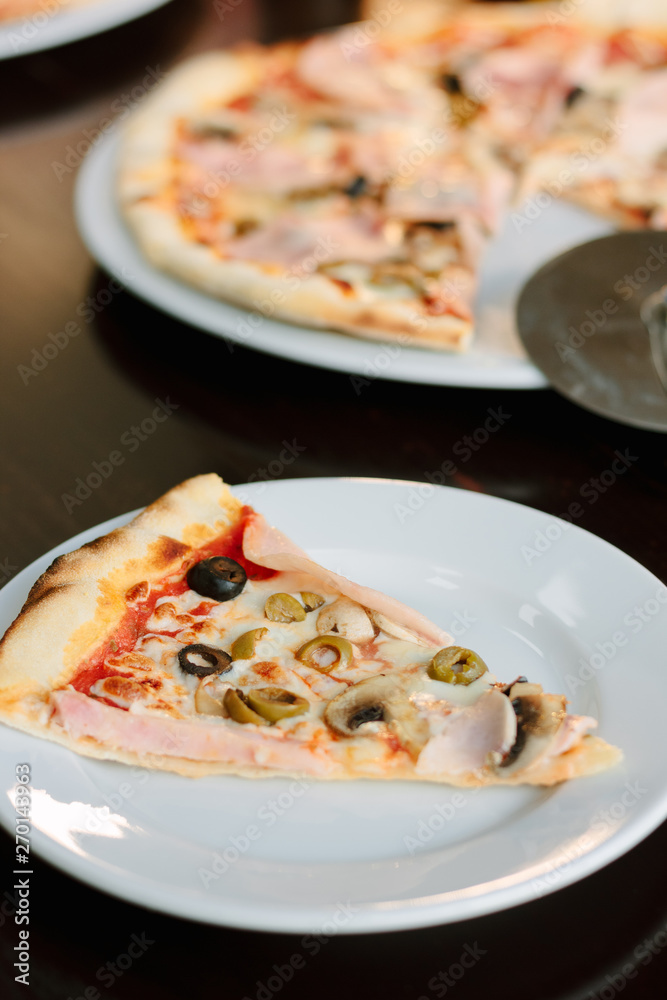 Mushroom pizza slice on white ceramic plate over the table.