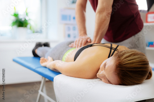 Pleasant relaxed woman receiving a back massage photo