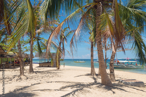 Sunny beach with palms on Luli Island, Honda bay, Palawan, Philippines