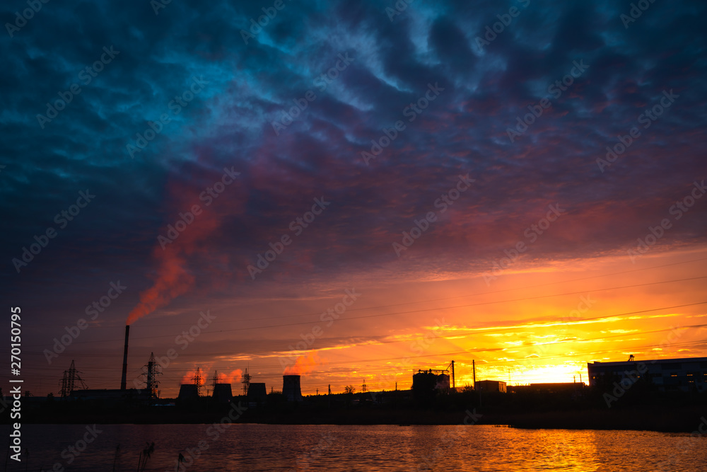 Thermal power plant reflecting in the lake at sunset. Blagoveshchensk, Russia