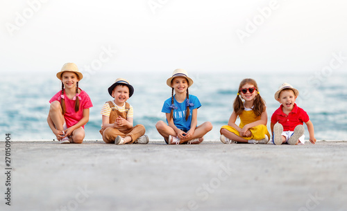 group of happy children by sea in summer.