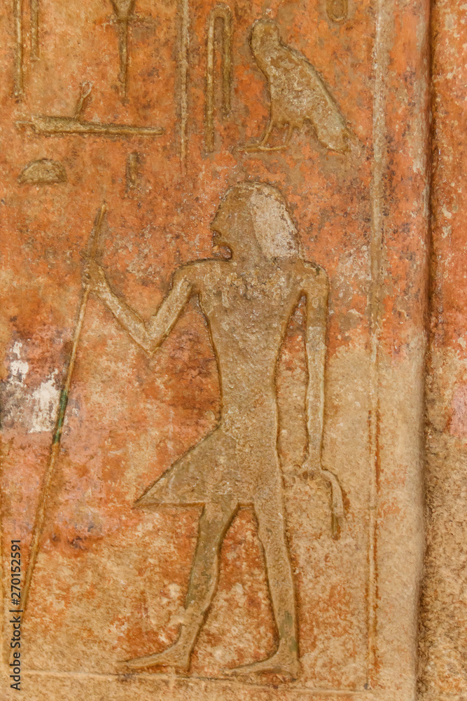 Ancient egyptian paintings and hieroglyphs carved on the stone wall