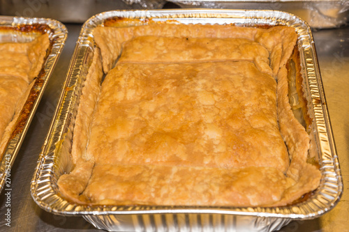 Freshly Baked Peach Cobbler:  Freshly baked peach cobbler in a pan ready to be served at a restaurant deli. 