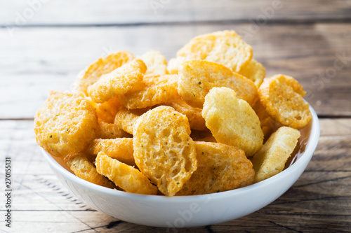 Croutons of white bread baguette with spices in dishes. Wooden background