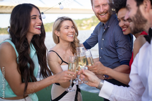 Group of friends drinking, chatting and having a fun at outdoor party