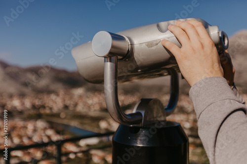 mans hands holding tourist binoculars
