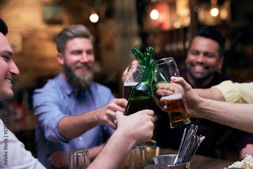 Group of men making a cheers for good weekend Group of men making a cheers for good weekend