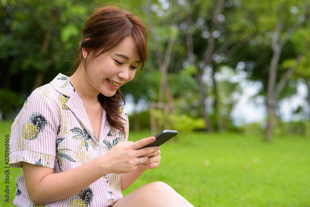 Young beautiful Asian tourist woman relaxing at the park Young beautiful Asian tourist woman relaxing at the park
